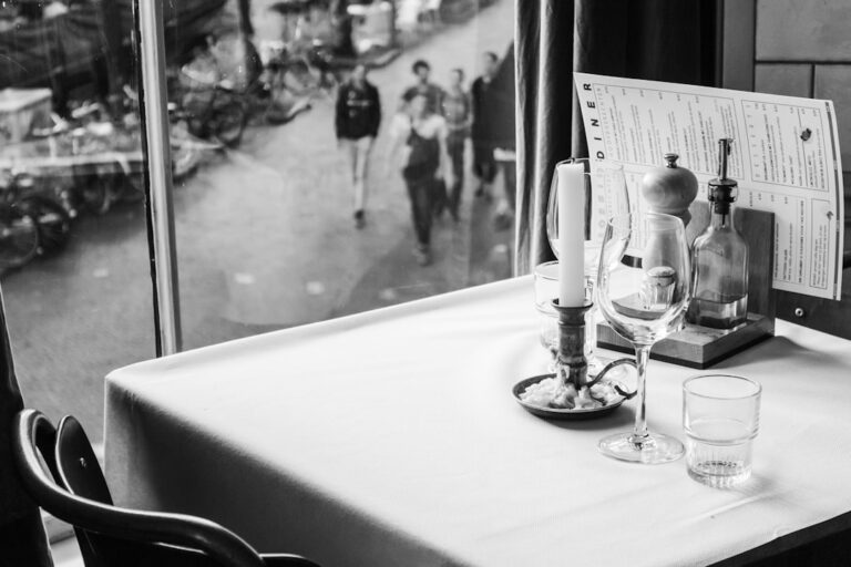 A group of people sitting at a restaurant table with a server taking their order.